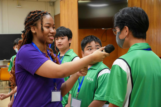 HKU camp tutor encourages participant to present their ideas in English